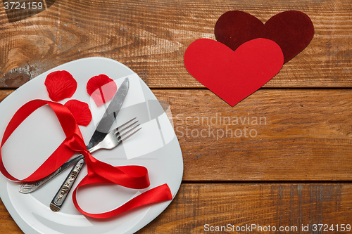 Image of The ribbon in plate on wooden background with a heart