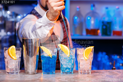 Image of Barman at work, preparing cocktails.
