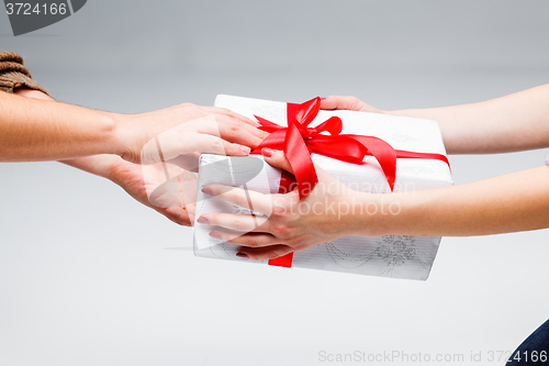 Image of Hands giving and receiving a present