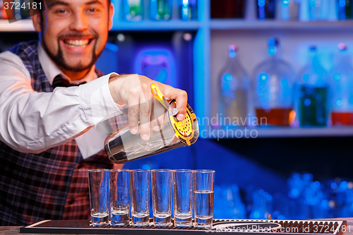 Image of Barman at work, preparing cocktails.