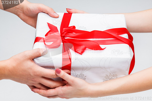 Image of Hands giving and receiving a present