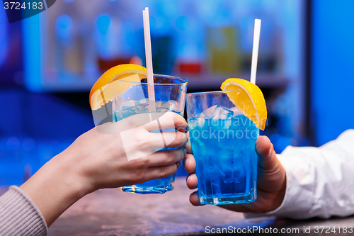 Image of The hands with alcohol cocktails making toast on a bar background