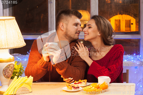 Image of The  happy young couple with cups of tea 