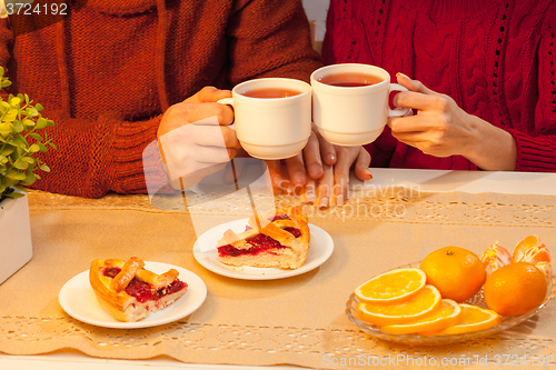 Image of The  happy young couple with cups of tea 