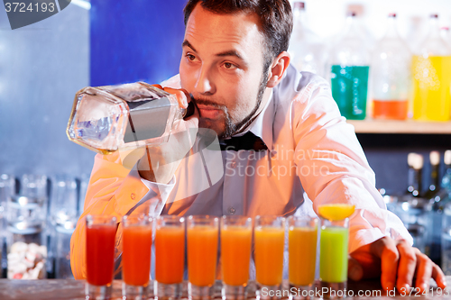 Image of Barman at work, preparing cocktails.