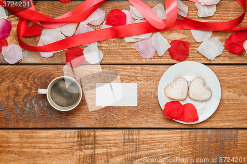 Image of The red  ribbon on  wooden background with a cup of coffee