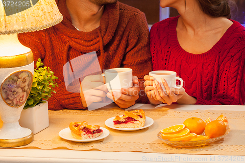 Image of The  happy young couple with cups of tea 