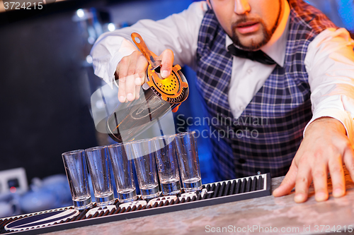 Image of Barman at work, preparing cocktails.