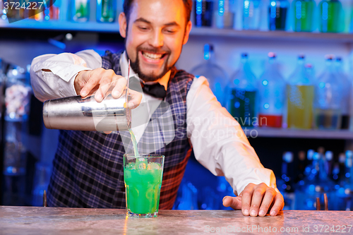 Image of Barman at work, preparing cocktails.