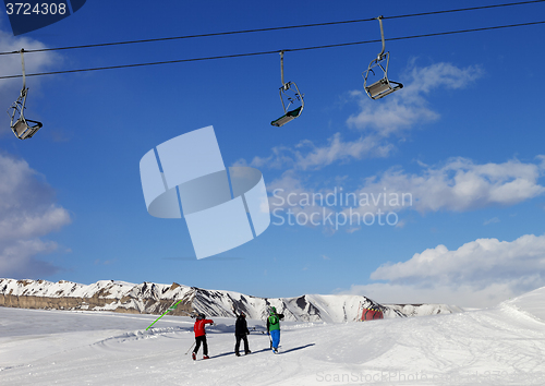 Image of Three skiers on slope at sun nice day