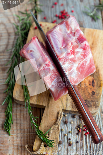 Image of Knife cutting pork loin. View from above.