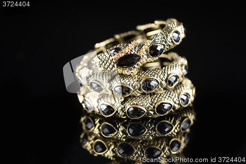 Image of golden bracelet form of snake isolated black background