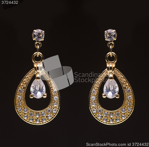 Image of gold earrings with white little stones 