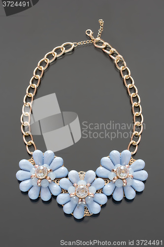 Image of plastic necklace. three blue flower