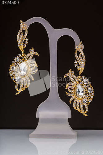 Image of gold earrings with white little stones 