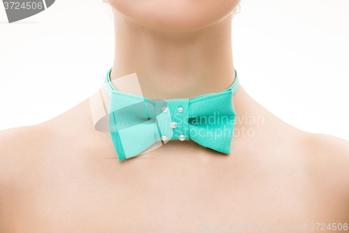 Image of green tie bow on female neck. 