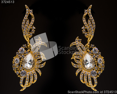 Image of gold earrings with white little stones 