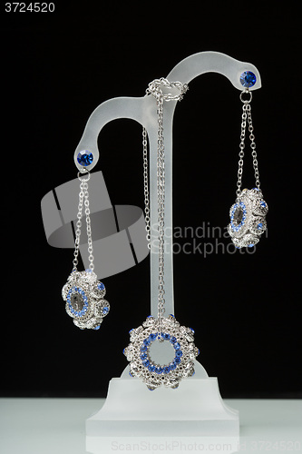 Image of earrings with blue stones on the black 