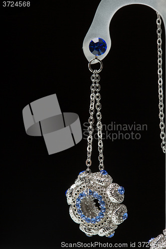 Image of earrings with blue stones on the black 