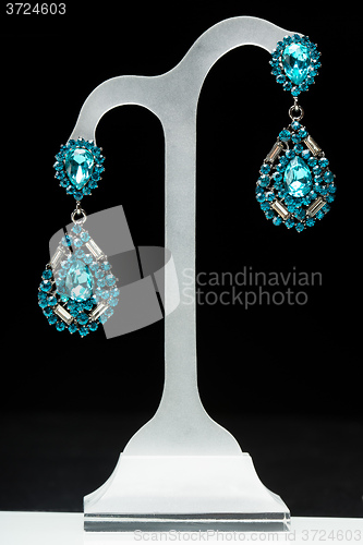 Image of earrings with blue stones on the black 