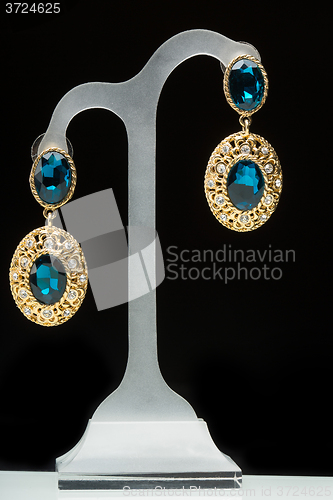 Image of earrings with blue stones on the black 