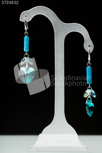 Image of earrings with blue stones on the black 