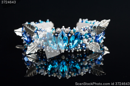 Image of diadem with large blue stones. bijouterie. on black background