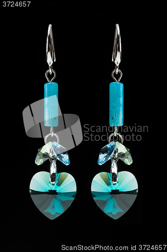 Image of earrings with blue stones on the black 