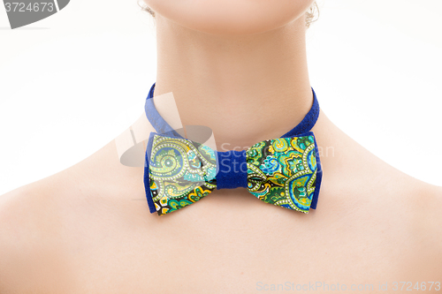 Image of patterned tie bow on female neck. 