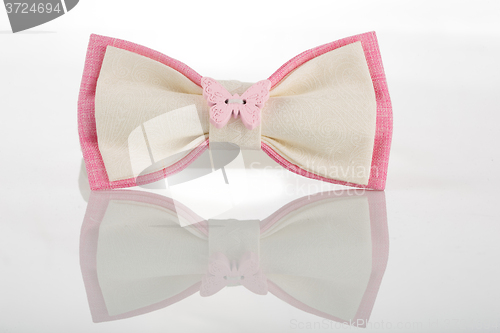 Image of white bow tie with pink accents and a butterfly