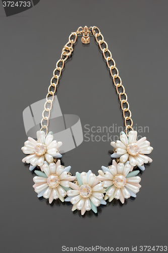 Image of plastic necklace. five beige flower