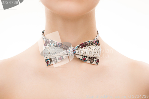 Image of patterned tie bow on female neck. 