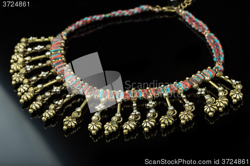 Image of metal feminine necklace. on black  background. 