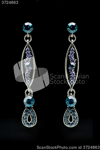 Image of earrings with blue stones on the black 