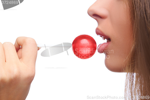 Image of closeup girl sucks a lollipop.  