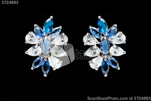 Image of earrings with blue stones on the black 