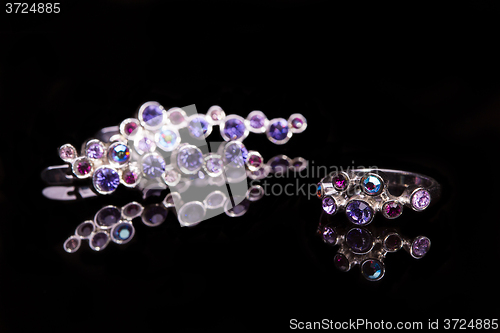 Image of earring and ring with colorful gems 