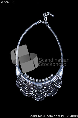 Image of metal feminine necklace. on black background. 