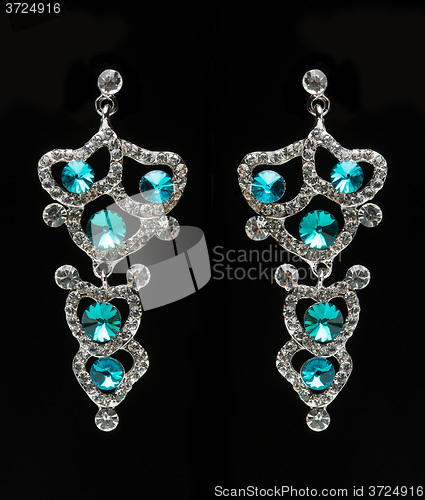Image of earrings with blue stones on the black 
