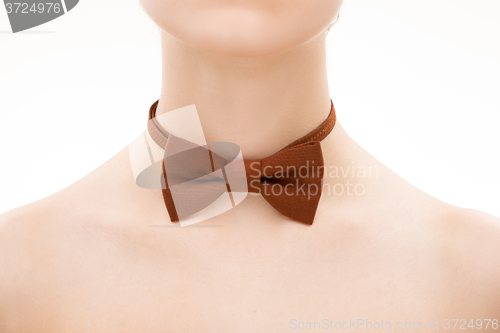 Image of brown tie bow on female neck. 