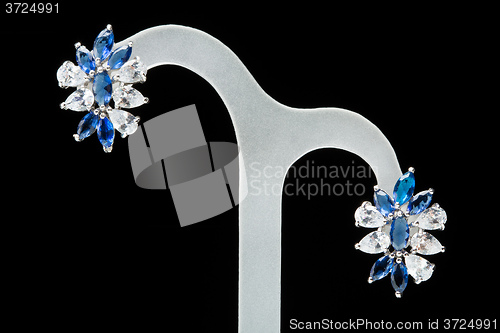 Image of earrings with blue stones on the black 