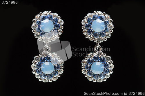 Image of earrings with blue stones on the black 