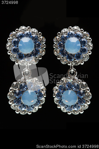 Image of earrings with blue stones on the black 