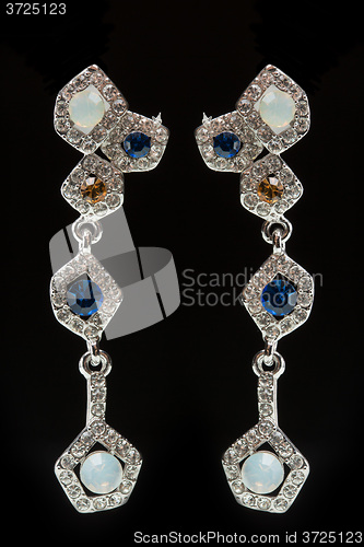 Image of earrings with blue stones on the black 