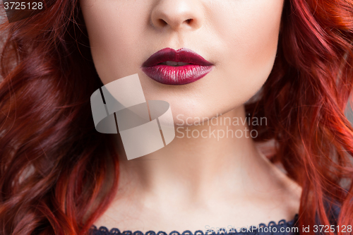 Image of closeup cherry lips. girl with red hair. the lower part of the face. Fashion Girl Portrait.