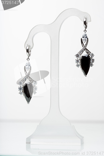 Image of earrings with black stones on the white