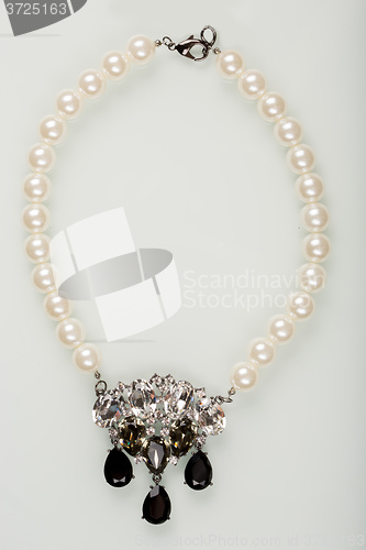 Image of pearl necklace with black stones on a white 