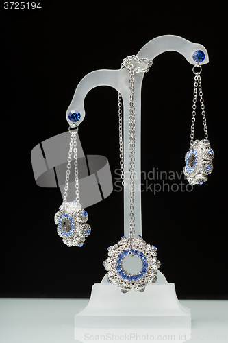 Image of earrings with blue stones on the black 