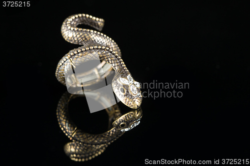 Image of ring with stones in the form of snake on black background