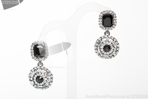 Image of earrings with black stones on the white